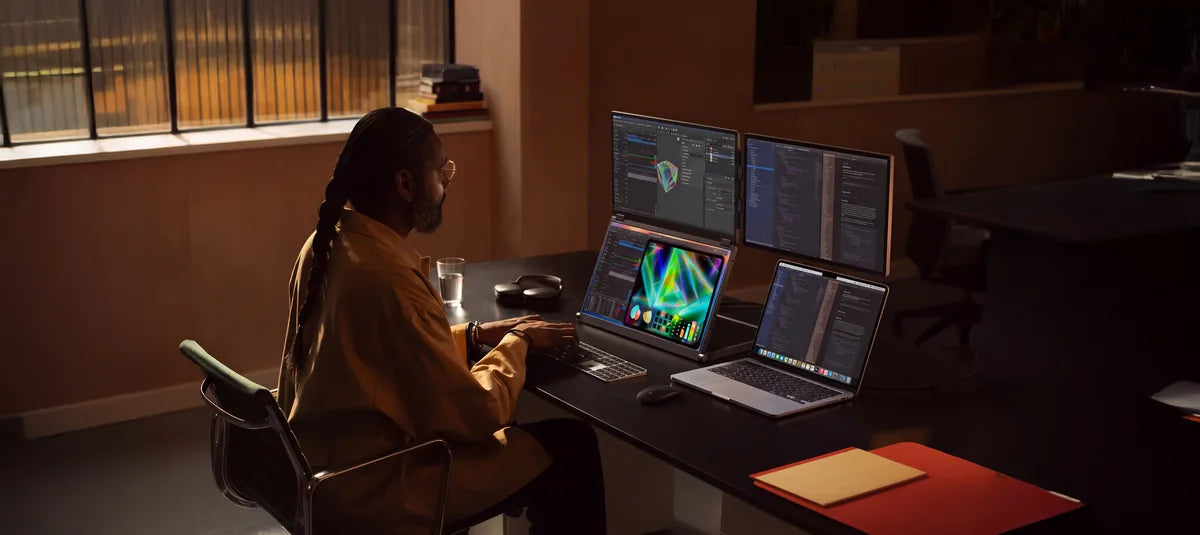A designer working with Fold 7 and a laptop in one field of view